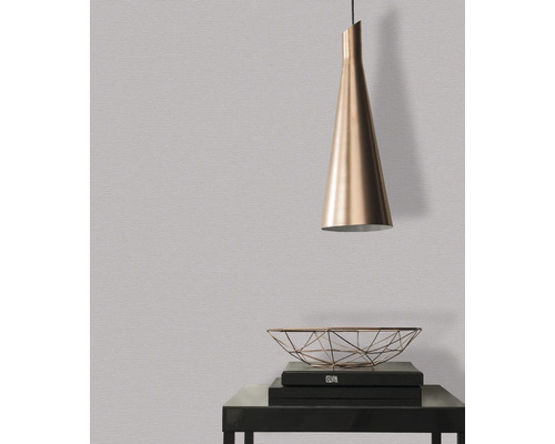 Nahaufnahme einer dezenten Wandtapete mit einer Pendelleuchte und Dekorationsgegenständen auf einem Tisch