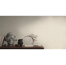 Wohnszene mit gemusterter Tapete, Bücherstapel und dekorativen Objekten auf einem Sideboard