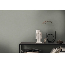 Dekoratives Arrangement auf einem schwarzen Regal mit Skulptur und Vase