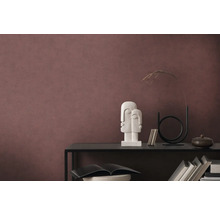 Dekoratives Arrangement auf einem schwarzen Regal vor einer Wand