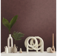 Dekorative Anordnung mit Vasen, Kerzenhalter und Zierobjekt auf einem Regal.