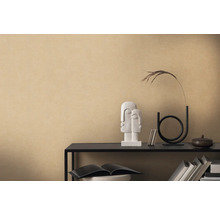 Dekoratives Arrangement mit Skulptur, Vase und Büchern auf einem Regal vor einer beigen Wand