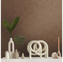 Dekorative Szene mit Vasen, Kerzen und Zierobjekten auf einer weißen Oberfläche