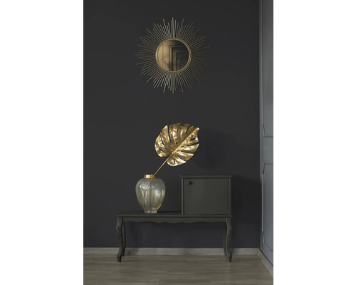 Dekorative Szene mit Spiegel, Monstera Blatt in Vase und kleinem Schrank auf einem Tisch