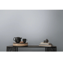 Dekorative Stilllebenanordnung auf einem Tisch mit Teekanne, Tasse, Schale und Büchern.