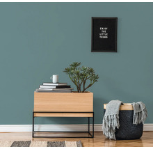 Dekoratives Wohnambiente mit Kommode, Pflanze, Korb und Wandbild