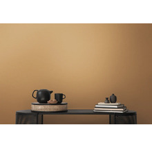 Dekorative Anordnung mit Teekanne, Tasse, Büchern und Vasen auf einem Tisch