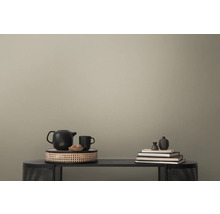 Dekorative Szene mit Teekanne, Tasse, Büchern und Vase auf einem Tisch