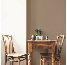 Holztisch mit zwei Stühlen, Teekanne, Pfeffermühle und Hyazinthen in Töpfen.