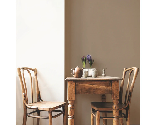 Holztisch mit zwei Stühlen, Teekanne, Pfeffermühle und Hyazinthen in Töpfen.