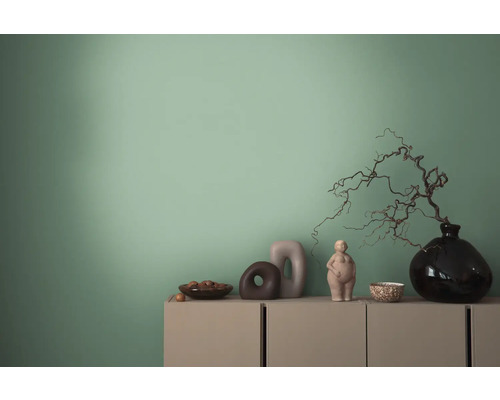 Dekorative Gegenstände auf einem Sideboard vor einer Wand