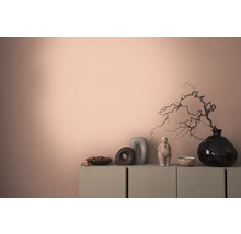 Dekoratives Interieur mit einer Kommode, Vasen und Skulpturen vor einer farbigen Wand.