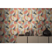 Wand mit geometrischer Tapete und dekorativen Objekten auf einem Schrank