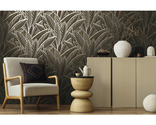 Wohnzimmer mit Sessel, Kommode und Tapete mit Blattmuster