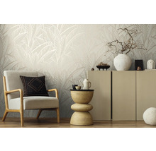 Wohnzimmer mit Sessel, Beistelltisch und Schrank vor einer Wand mit Blattmuster-Tapete