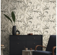 Wohnraum mit floral gemusterter Tapete, Kommode und Sessel