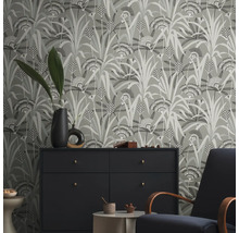 Raumansicht mit floral gemusterter Tapete, Kommode und Sessel