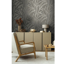 Wohnzimmer mit gemusterter Tapete, Sessel, Sideboard und Dekoration