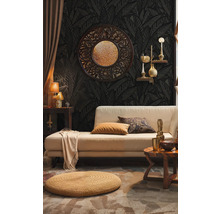 Wohnzimmer mit Sofa, Ziertisch und Dekorationen vor dunkler gemusterter Tapete