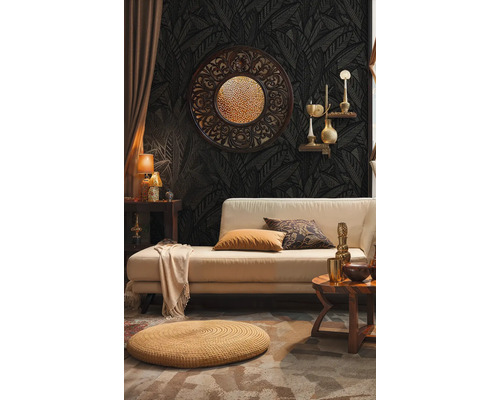 Wohnzimmer mit Sofa, Ziertisch und Dekorationen vor dunkler gemusterter Tapete