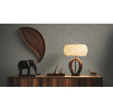 Wohnraum mit Kommode, Lampe und Dekorationen vor einer grauen Tapete mit Muster