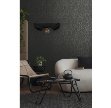 Wohnzimmer mit Sofa, Sessel, Tisch, Hängelampe und gemusterter Tapete.