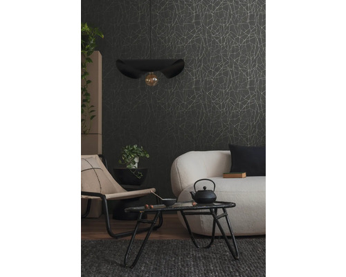 Wohnzimmer mit Sofa, Sessel, Tisch, Hängelampe und gemusterter Tapete.