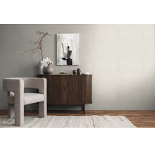 Helles Wohnzimmer mit Sessel, Sideboard, abstrakter Kunst und Dekorationen