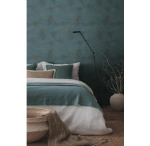 Schlafzimmer mit gemusterten Tapeten, Bett und Stehlampe