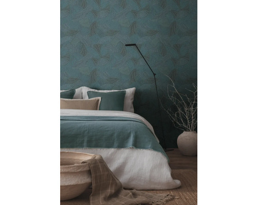 Schlafzimmer mit gemusterten Tapeten, Bett und Stehlampe