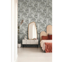 Schlafzimmer mit gemusterter Tapete, Kommode, Spiegel und Bett