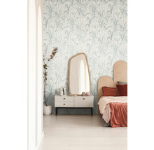Helles Schlafzimmer mit Tapete mit Pflanzenmuster, Spiegel und Kommode.