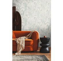 Wohnzimmer mit gemusterter Tapete, Sofa und Beistelltisch.