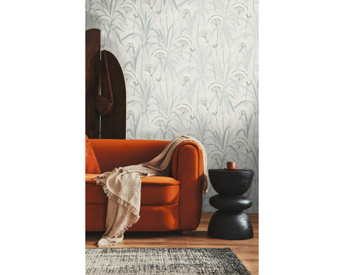 Wohnzimmer mit gemusterter Tapete, Sofa und Beistelltisch.