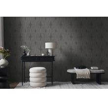 Wohnzimmer mit gemusterter Tapete, Schreibtisch, Lampe und Sitzgelegenheiten.