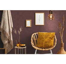 Wohnraum mit Rattansessel, Kissen, Beistelltisch, Dekoration und Wandbildern