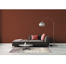 Wohnzimmer mit Sofa, Stehlampe und Teppich auf Betonboden vor brauner Wand