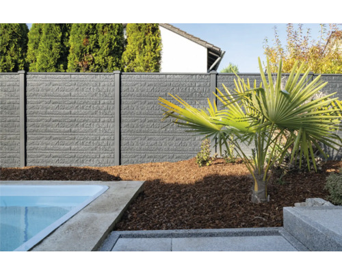 Clôture grise avec structure de mur à côté d''une piscine et d''un palmier