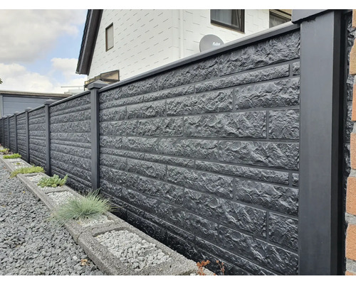 Longue clôture maçonnée avec piliers gris foncé