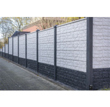 Un long mur antibruit gris avec des poteaux délimite une propriété.