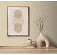 Scène décorative avec une œuvre d''art abstraite encadrée, un vase avec des fleurs, des livres et une tasse sur une table.