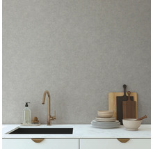 Scène de cuisine avec évier, robinet, vaisselle et planches à découper devant un mur gris clair