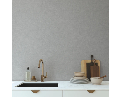 Scène de cuisine avec évier, robinet, vaisselle et planches à découper sur un plan de travail.