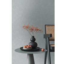 Scène décorative avec table, vase, fleurs séchées, coupe de fruits et chaise devant un mur
