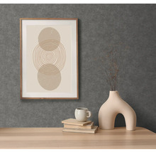 Scène décorative avec une impression graphique encadrée, une tasse, des livres et un vase original