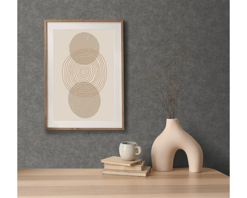 Scène décorative avec une impression graphique encadrée, une tasse, des livres et un vase original