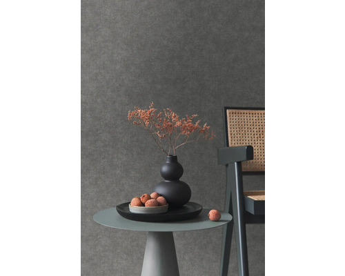 Gros plan d''une table avec décoration devant un papier peint mural sombre.