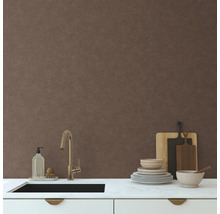 Scène de cuisine avec évier, vaisselle et planches à découper devant un mur avec du papier peint textile