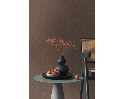 Scène décorative avec vase, fleurs séchées, litchis, table d''appoint et chaise devant un mur