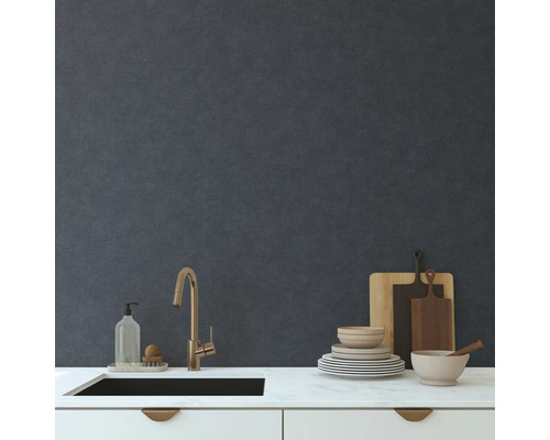 Évier de cuisine avec robinet, vaisselle, planches à découper et liquide vaisselle sur un plan de travail devant un mur